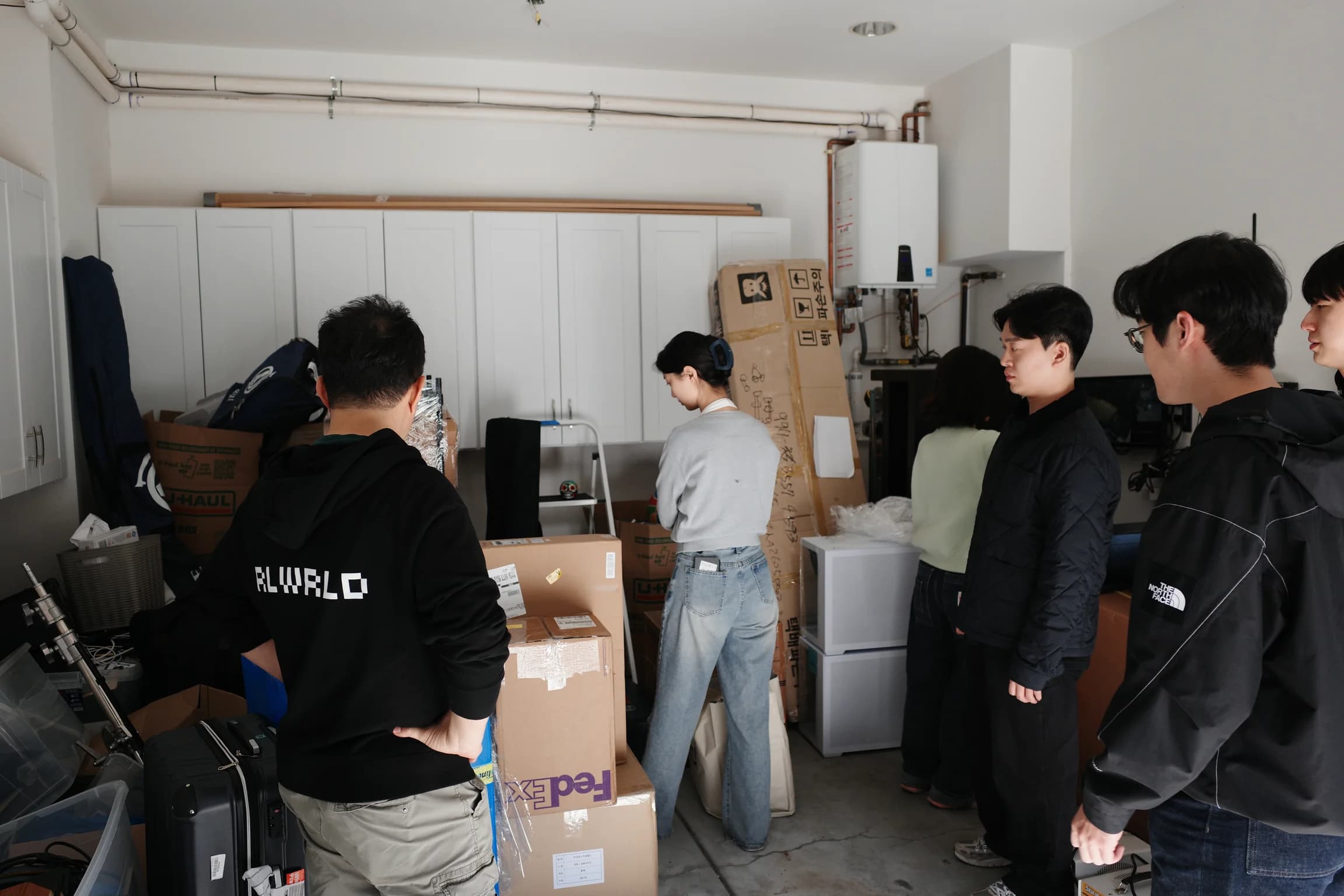 The team among stacked FedEx and U-Haul boxes in the load-in garage