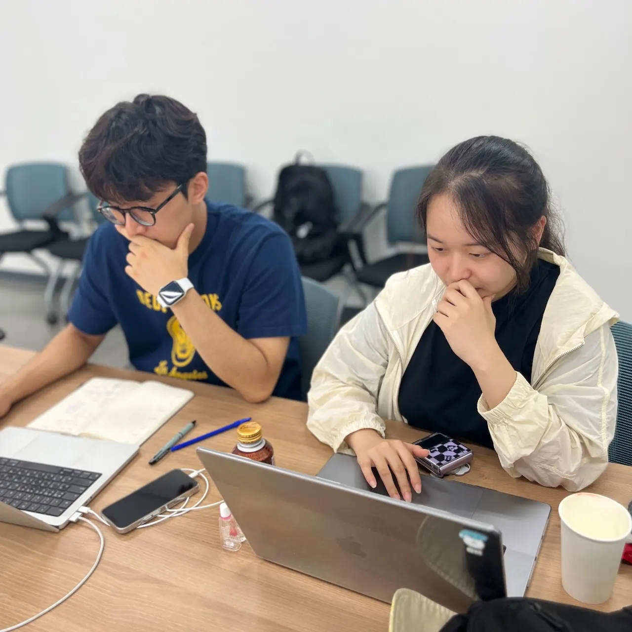 Working through a project on laptops with a teammate