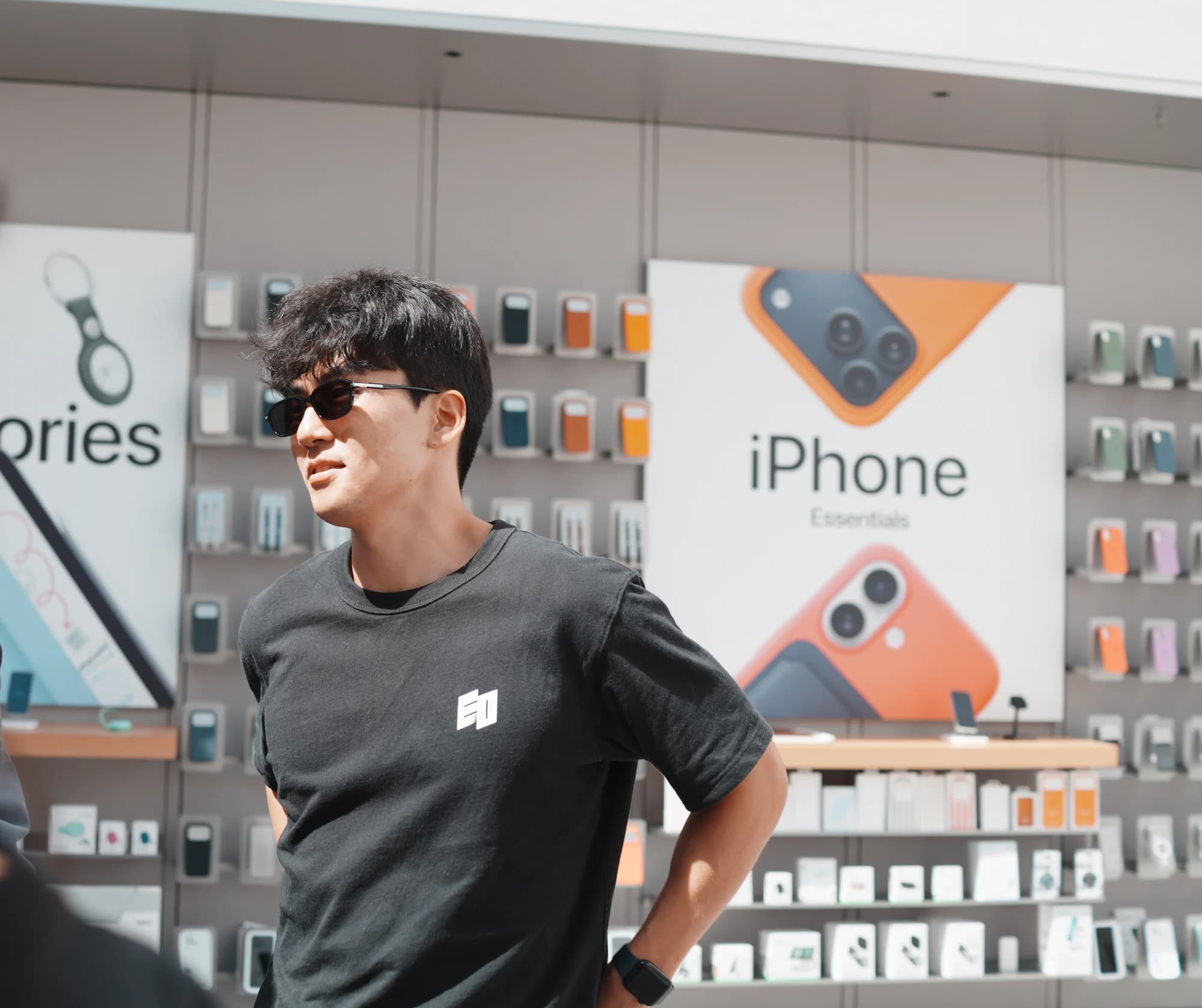 The EO tee worn in an Apple Store: black, with the white EO mark small on the left chest
